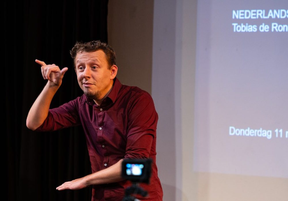 Docent Tobias geeft een workshop bij een organisatie